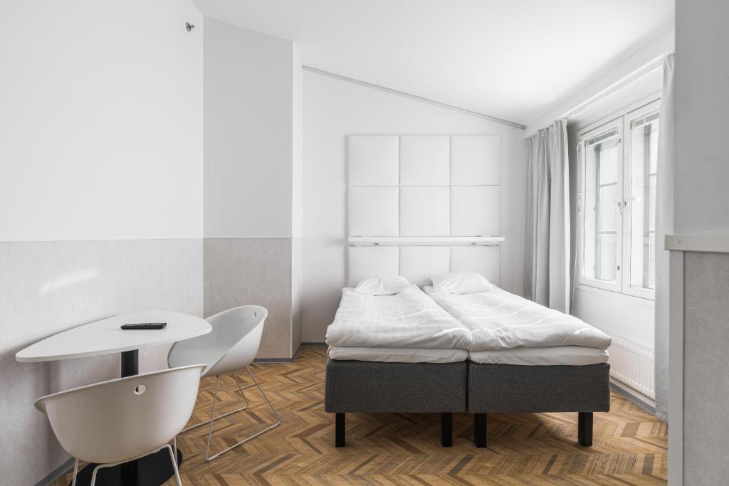 um quarto com uma cama, uma mesa e uma cadeira em Omena Hotel Turku Kauppiaskatu em Turku