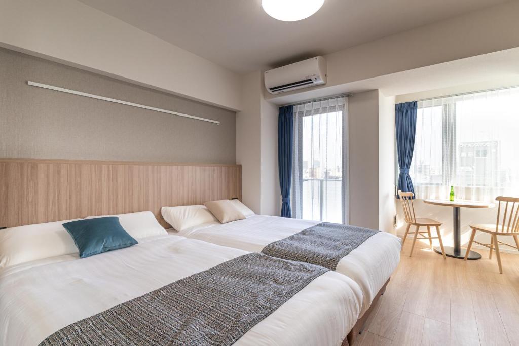 um quarto com uma cama grande e uma mesa em BON Tokyo Asakusa em Tóquio