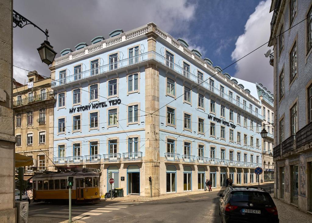 a large white building with a tram in front of it at My Story Hotel Tejo in Lisbon