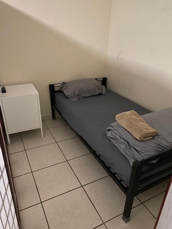 ein kleines Zimmer mit einem Bett und einem Nachttisch in der Unterkunft Private Cubicle - Single Bed - Mixed Shared Dorm - MIAMI AIRPORT in Miami