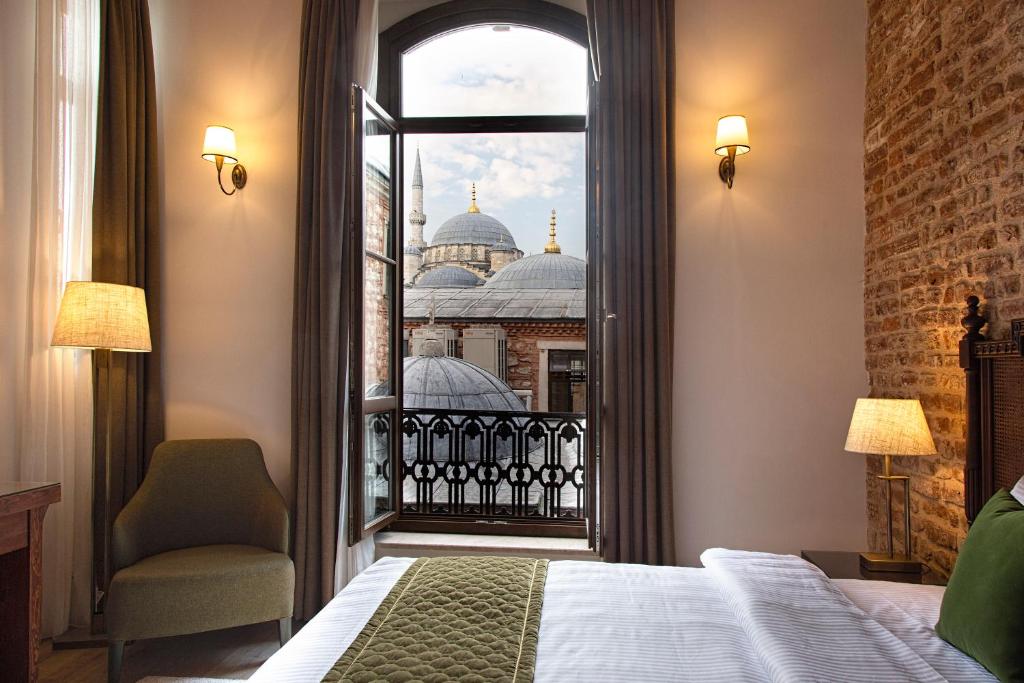 ein Schlafzimmer mit Blick auf eine Moschee aus dem Fenster in der Unterkunft Mest Hotel Istanbul Sirkeci in Istanbul