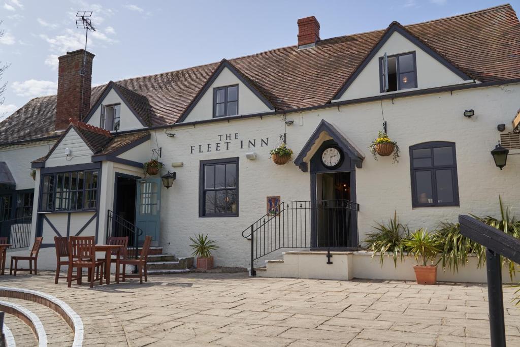 una locanda con tavoli e sedie di fronte di The Fleet Inn a Tewkesbury