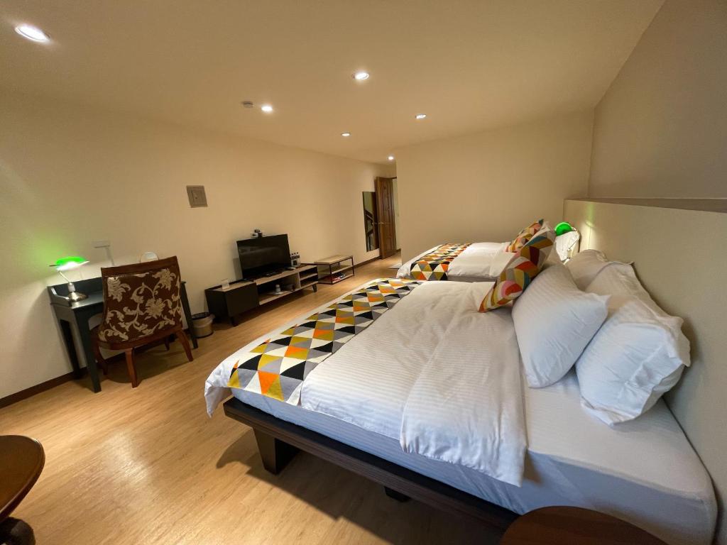 a bedroom with a large bed and a television at 墾丁聚點旅棧 2Ps Hotel in Kenting