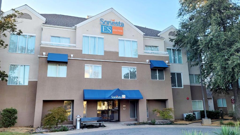 a rendering of a hotel building with blue awnings at Sonesta ES Suites Dallas Medical Market Center in Dallas