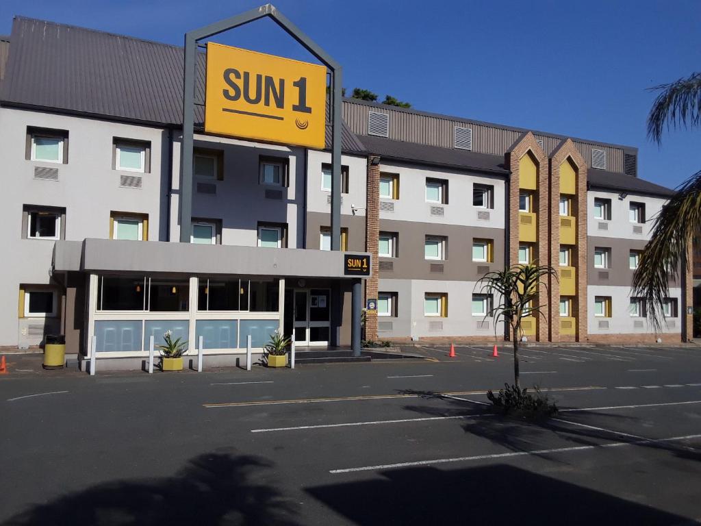 a building with a sun sign in front of a parking lot at SUN1 Durban in Durban