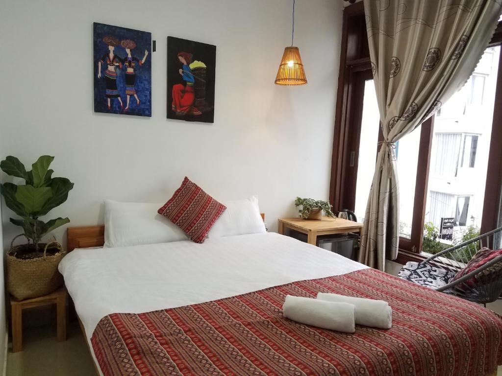 - une chambre avec un lit et 2 serviettes dans l'établissement Hotel Làng Kò Hơ, à Đà Lạt