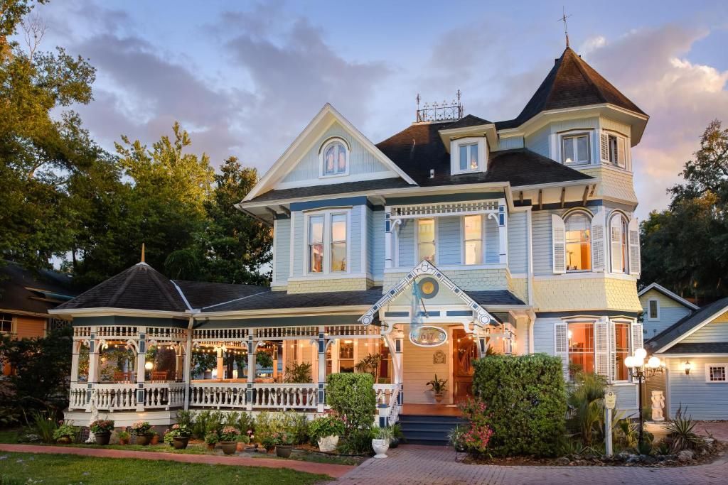 a large blue house with a porch at Sweetwater Branch Inn in Gainesville