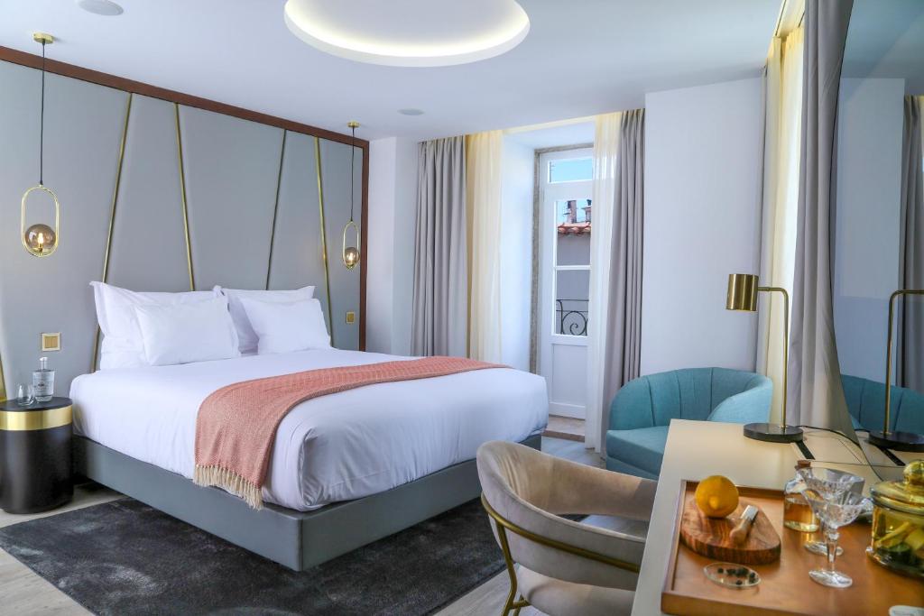 Habitación de hotel con cama, mesa y sillas en São Vicente Alfama Hotel by TRIUS Hotels, en Lisboa