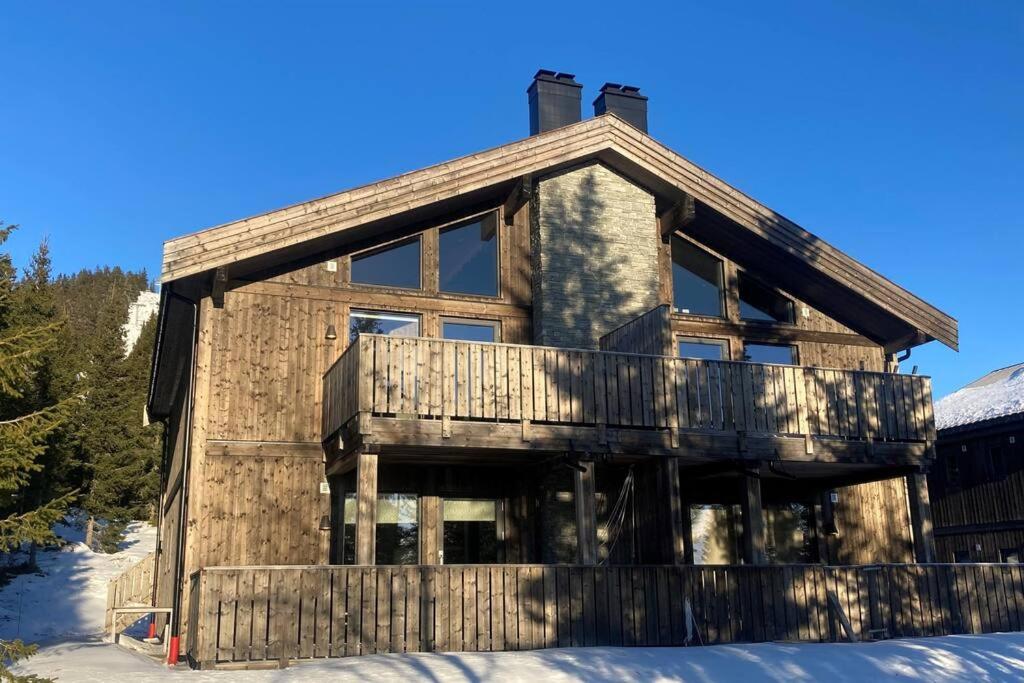 a log cabin in the snow at Apartment with Electric car charger ski in out in Sjusjøen