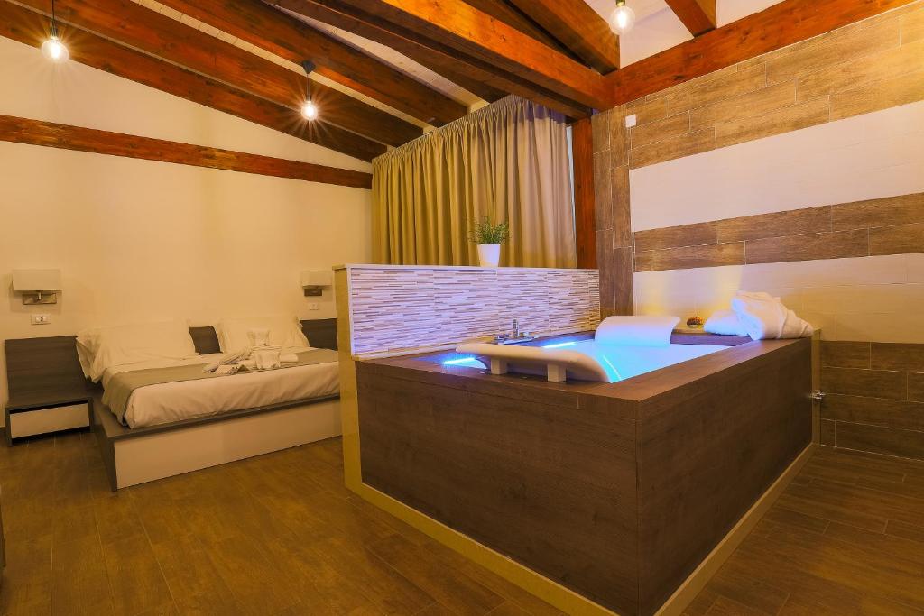 a bathroom with a tub and a bed in a room at Il Semaforo Sila Hotel in Taverna