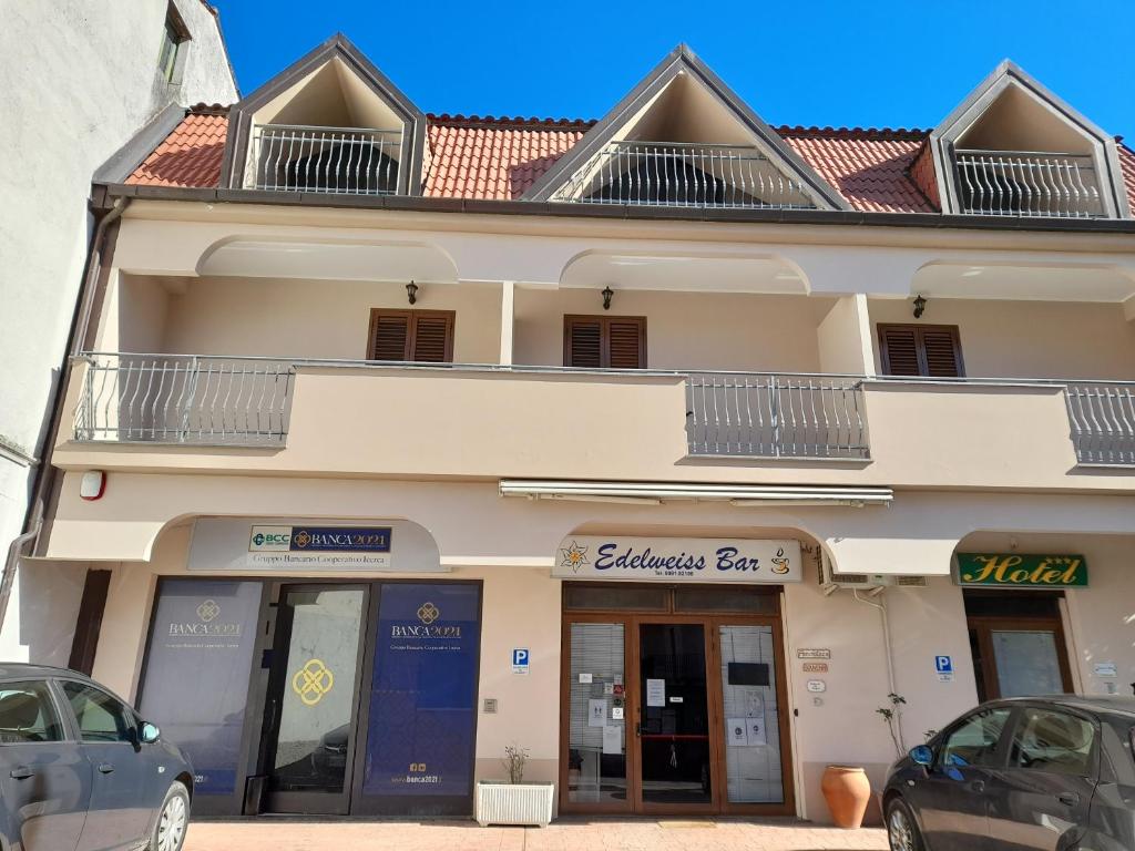 a building with cars parked in front of it at Hotel Edelweiss in Laino Borgo