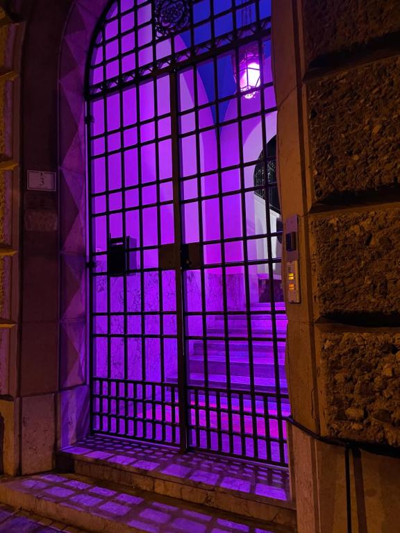 a purple light shines through a metal gate at PALAZZO FIACCADORI - Historical Palace in Reggio di Calabria