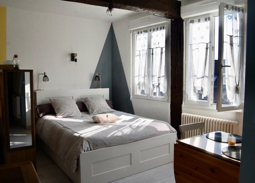 - une chambre avec un lit et 2 fenêtres dans l'établissement L IMPREVU, à Chartres