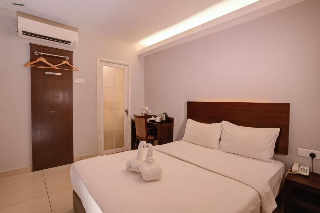 a bedroom with a large white bed with white towels on it at GM Metro at Sunway in Petaling Jaya