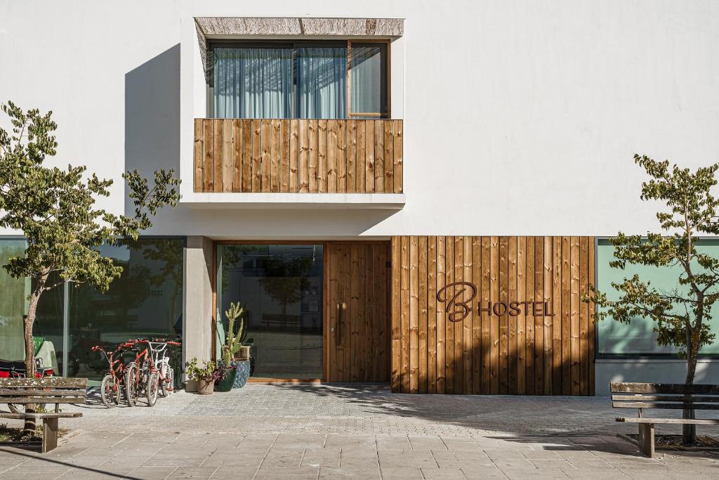 um edifício com uma porta de madeira com uma placa em B.Hostel na Comporta