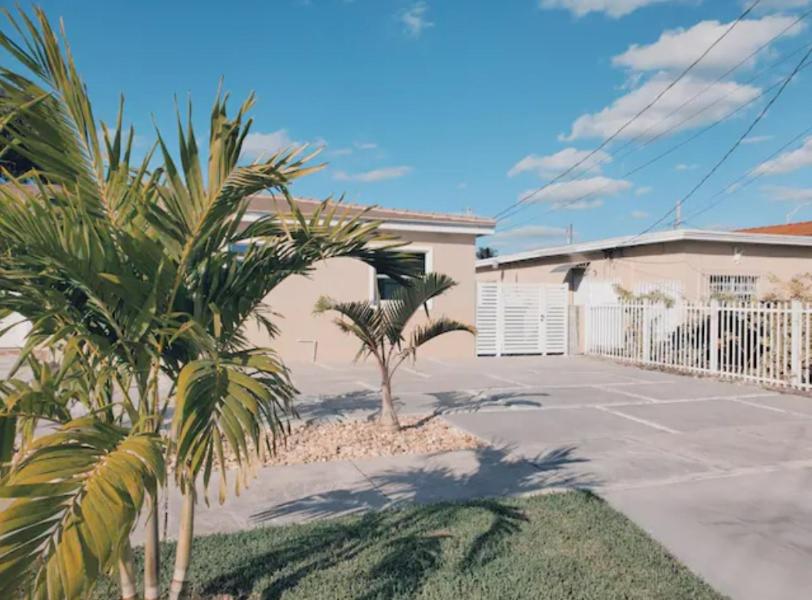 ein Haus mit Palmen vor einer Einfahrt in der Unterkunft Guayabita's House in Miami