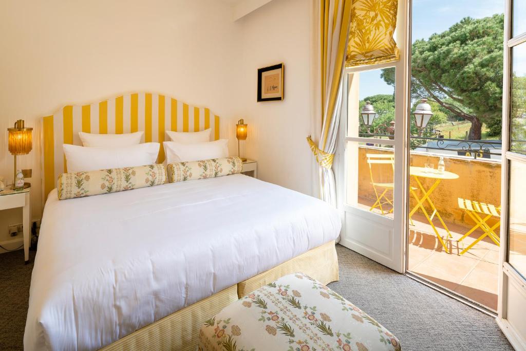 ein Schlafzimmer mit einem Bett und einem großen Fenster in der Unterkunft Hôtel Le Y in Saint-Tropez