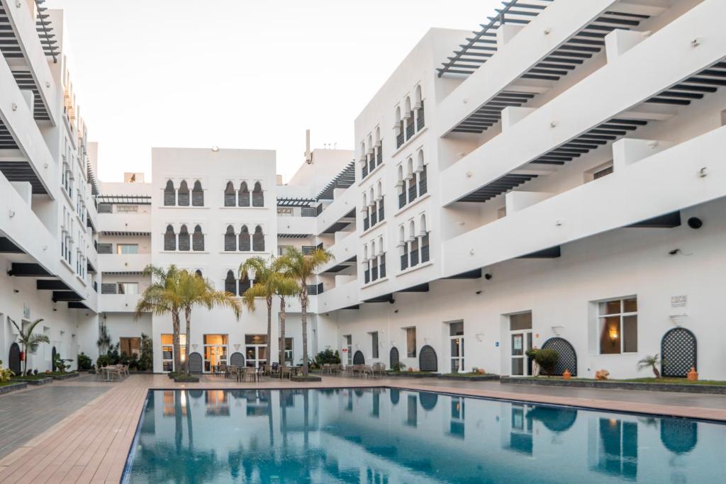 un'immagine del cortile di un edificio con piscina di Hotel Andalucia Tangier a Tangeri