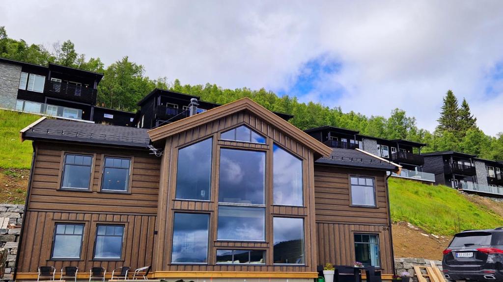 uma casa com um reflexo do céu nas janelas em Mlodge - The Mountain Lodge em Sogndal