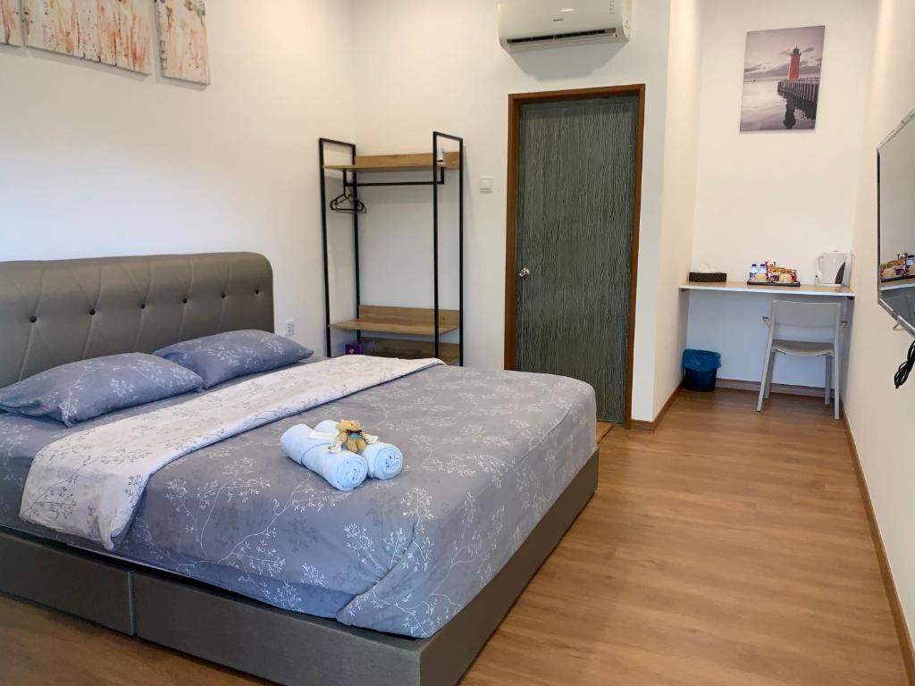 una camera da letto con un letto con due orsacchiotti sopra di Raintown Cottage a Taiping