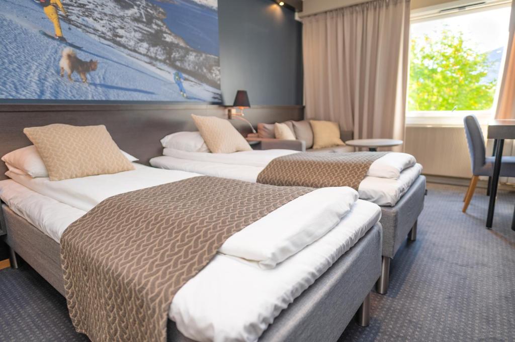 een hotelkamer met drie bedden in een kamer bij Hotell Maritim Skjervoy in Skjervøy