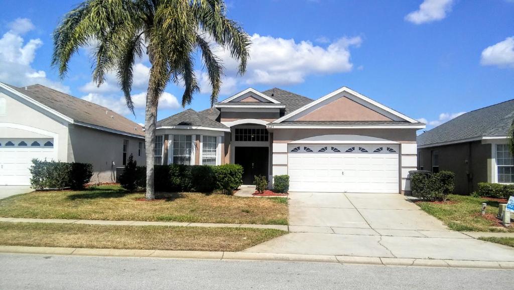 uma casa com uma palmeira em frente em Formosa Garden Pool Home em Orlando