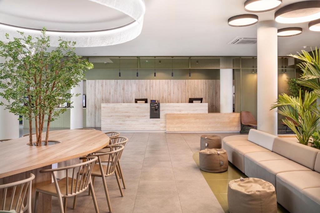 a lobby with tables and chairs and a waiting area at B&B HOTEL Lisboa Aeroporto in Lisbon