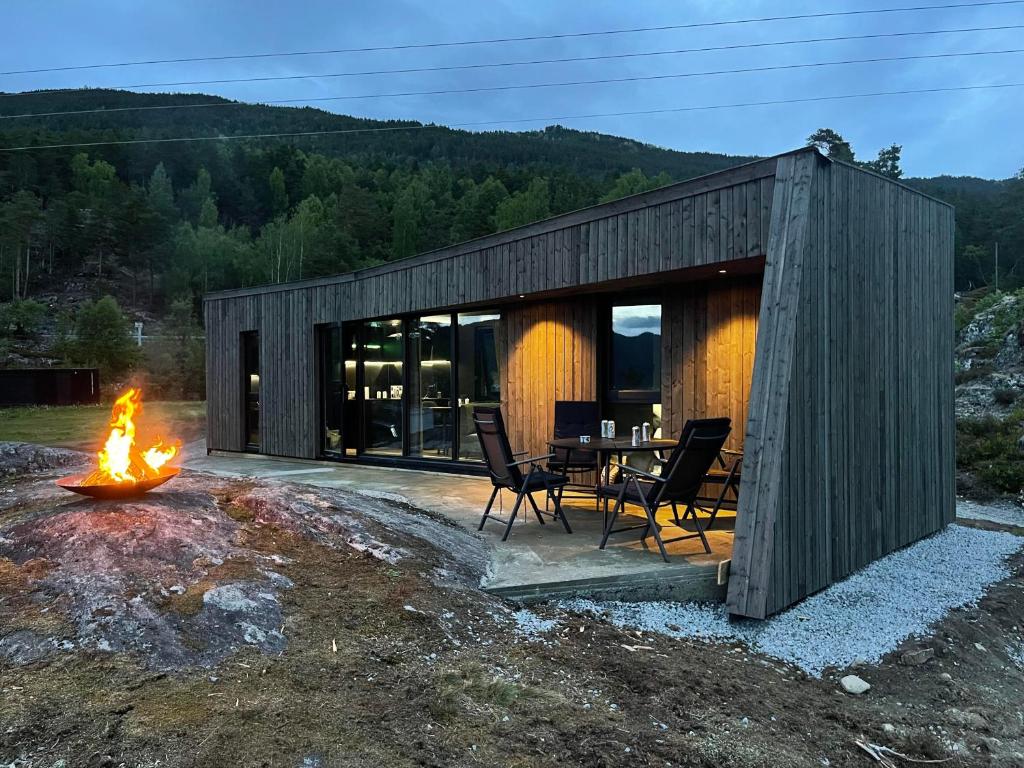 uma cabana de madeira com uma mesa e cadeiras e uma lareira em Sogndal Fjordpanorama em Sogndal