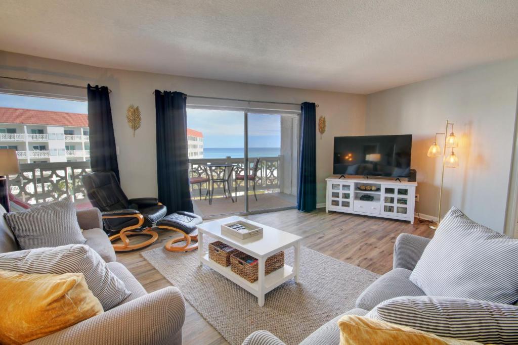 a living room with a couch and a tv at El Matador 454 - Beautiful views of the Gulf and pool - Includes seasonal beach service! in Fort Walton Beach