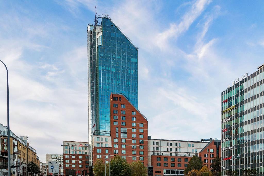 un edificio alto de cristal en una ciudad con edificios en Best Western Plus Hotel Plaza, en Västerås