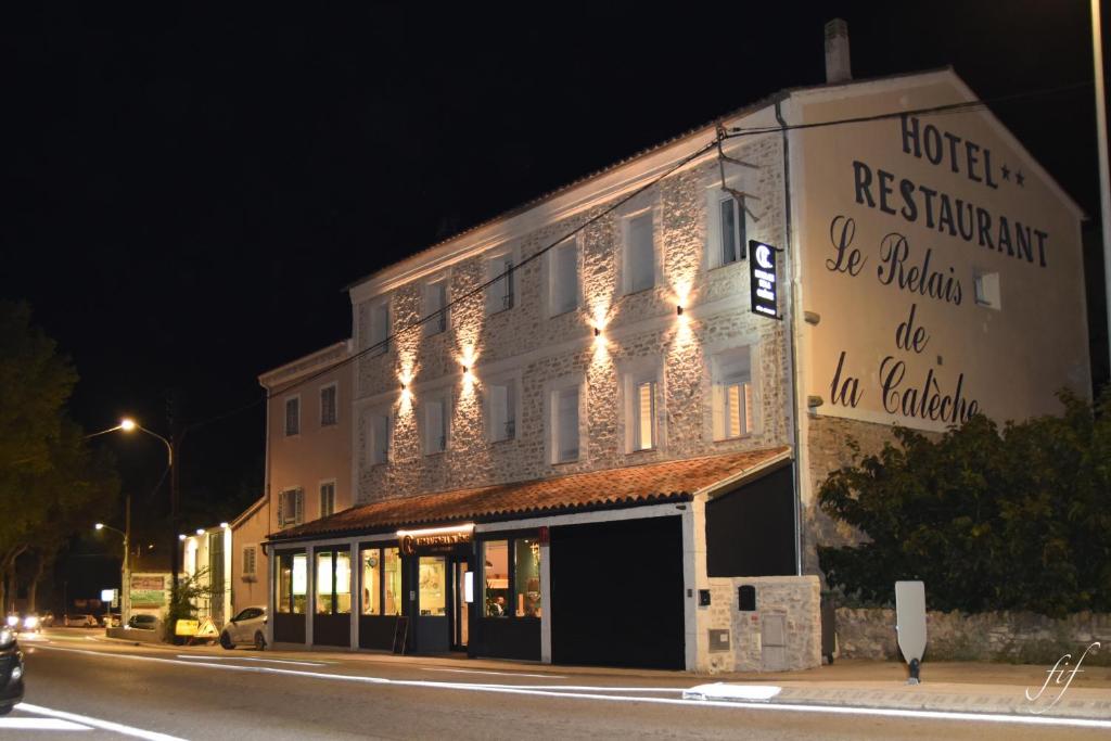 ein Gebäude am Straßenrand in der Nacht in der Unterkunft Le Relais de la Calèche in Le Beausset