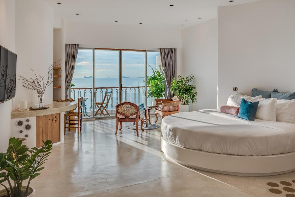 - une chambre avec un grand lit et un balcon dans l'établissement Ampersand Resort, à Bophut 