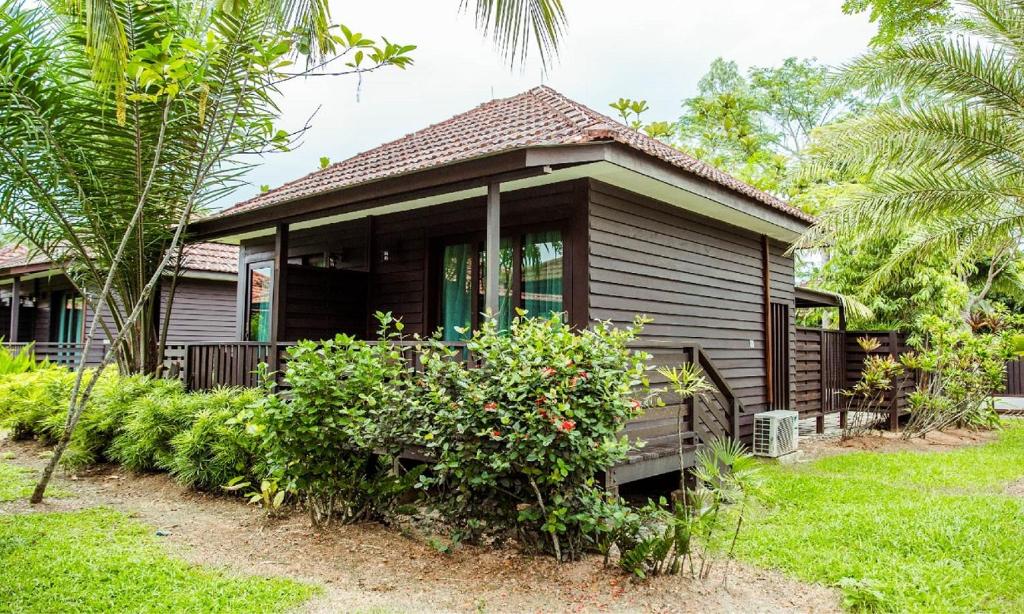 uma pequena casa num quintal com árvores e plantas em Kranji Sanctuary Resort em Singapura