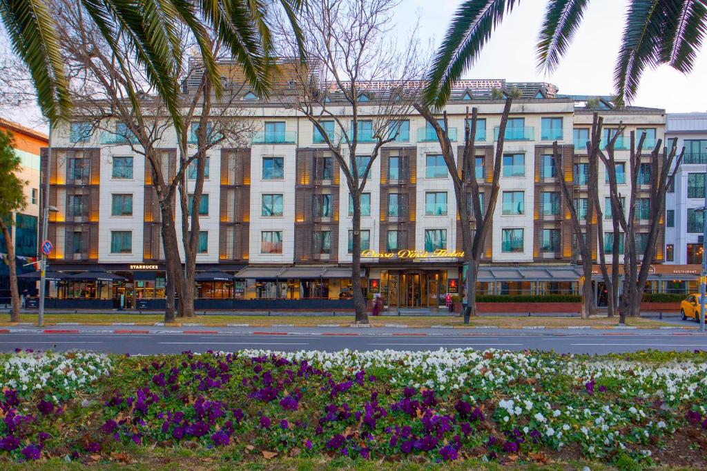 ein großes weißes Gebäude mit Palmen und Blumen in der Unterkunft Dosso Dossi Hotels & Spa Downtown in Istanbul