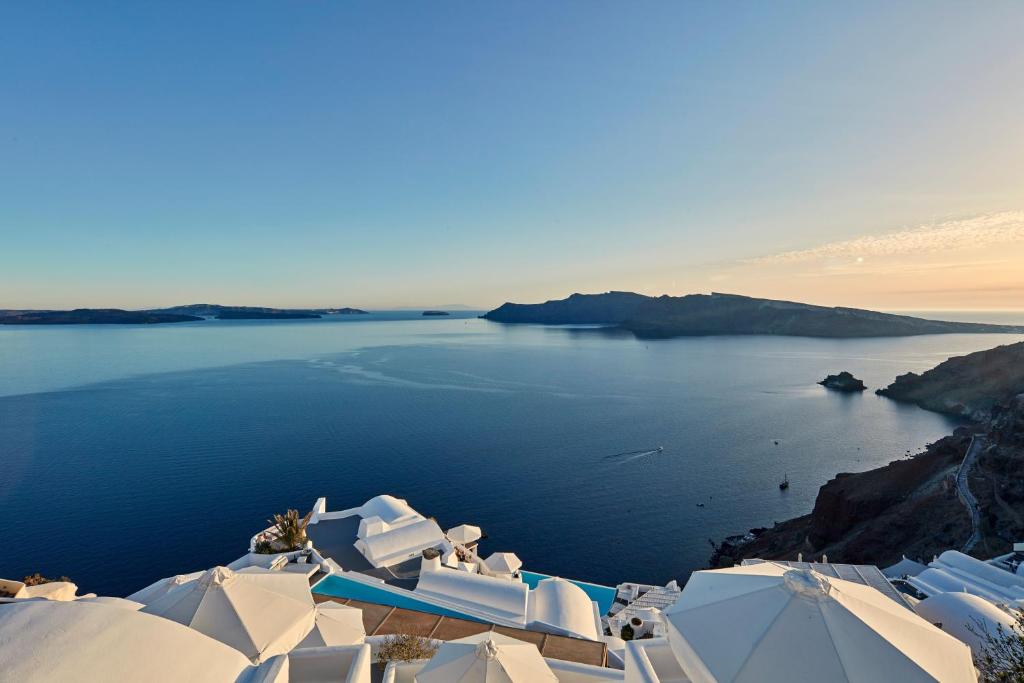 Blick auf einen Wasserkörper mit weißen Gebäuden in der Unterkunft Katikies Santorini - The Leading Hotels Of The World in Oia