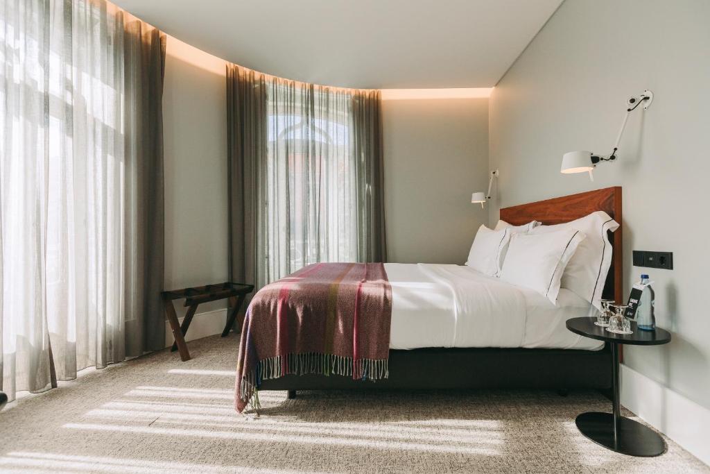 1 dormitorio con cama y ventana grande en 1908 Lisboa Hotel, en Lisboa