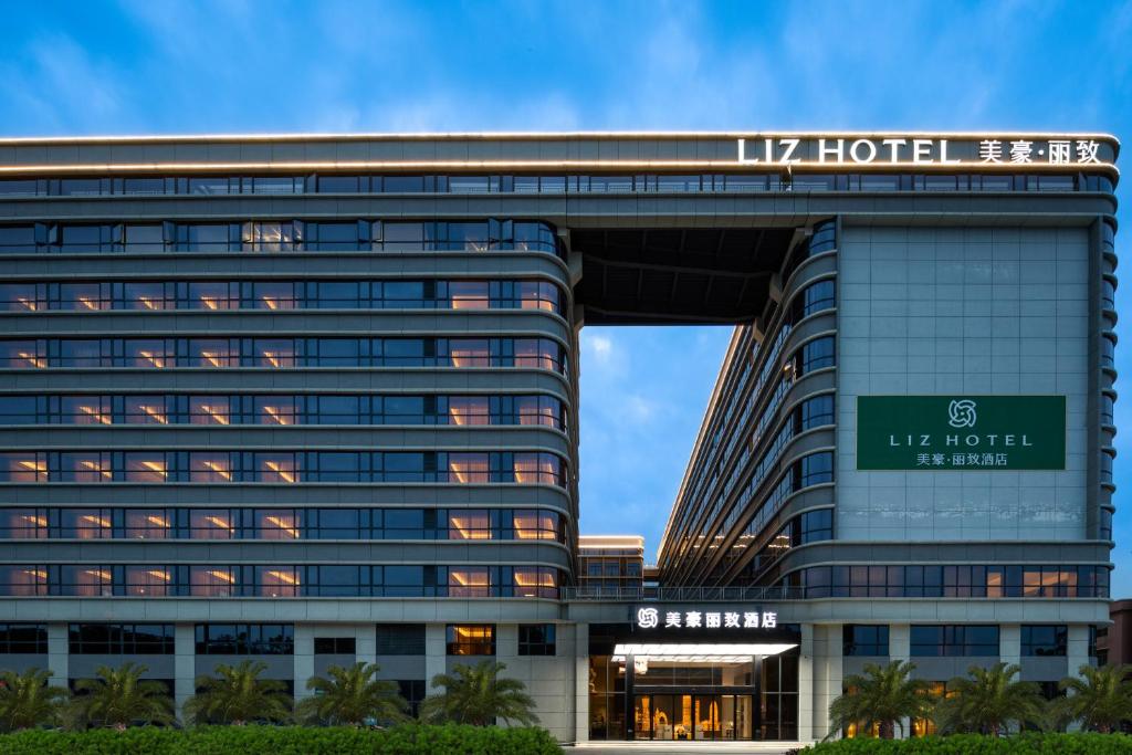 um edifício com um sinal em cima em Guangzhou Baiyun Airport MeHood Liz Hotel Free AirPort Shuttle Bus em Guangzhou