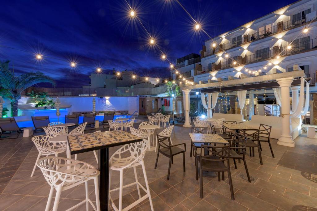 an outdoor patio with tables and chairs at night at Hotel Boutique Sibarys - Adults Recommended in Nerja