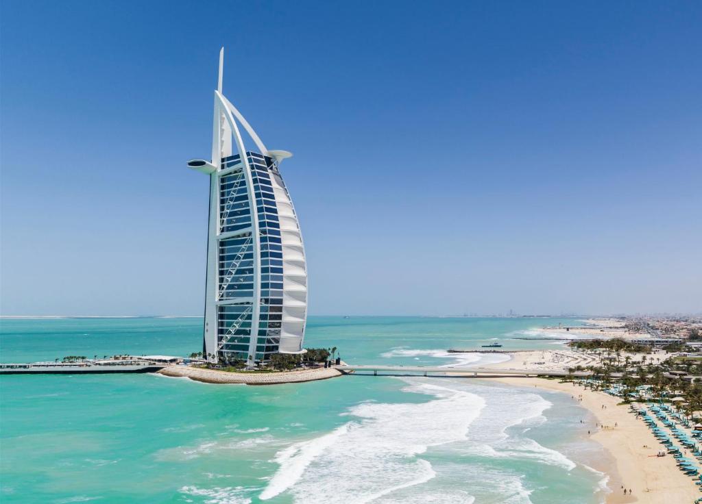 ドバイにあるJumeirah Burj Al Arab Dubaiのブルジュ・アル・アラブのホテルとビーチの景色を望めます。