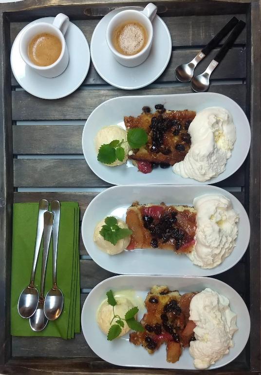 una mesa con platos de comida y tazas de café en Évika boutique hotel, en Eskilsby