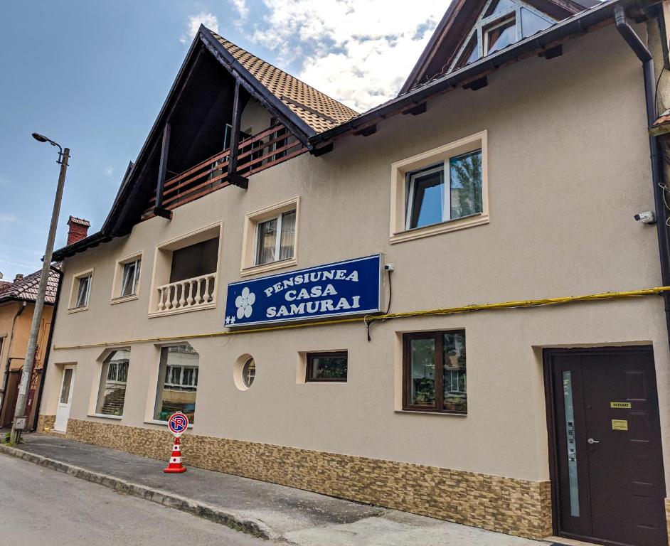 ein Gebäude mit einem Schild an der Seite in der Unterkunft Pension Casa Samurai in Braşov