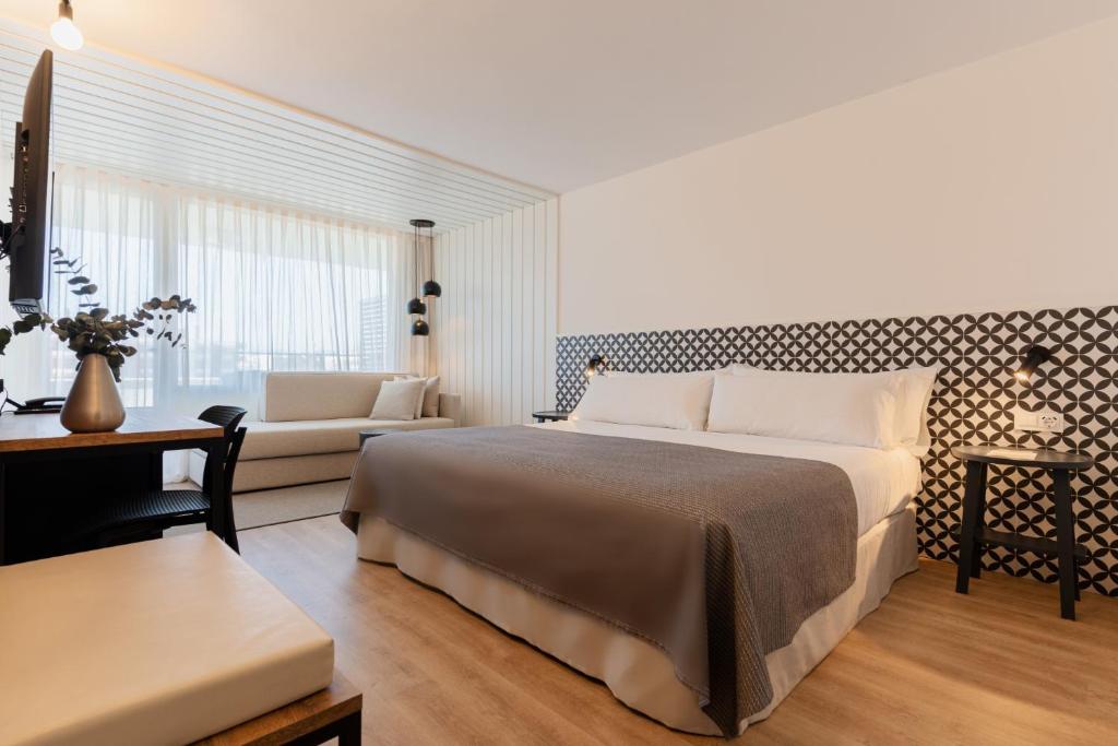 1 dormitorio con 1 cama grande y 1 sofá en Magnolia Hotel - Adults Only, en Salou