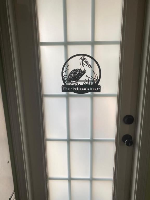 a sign on a window with a bird on it at The Pelican’s Nest in Panama City Beach