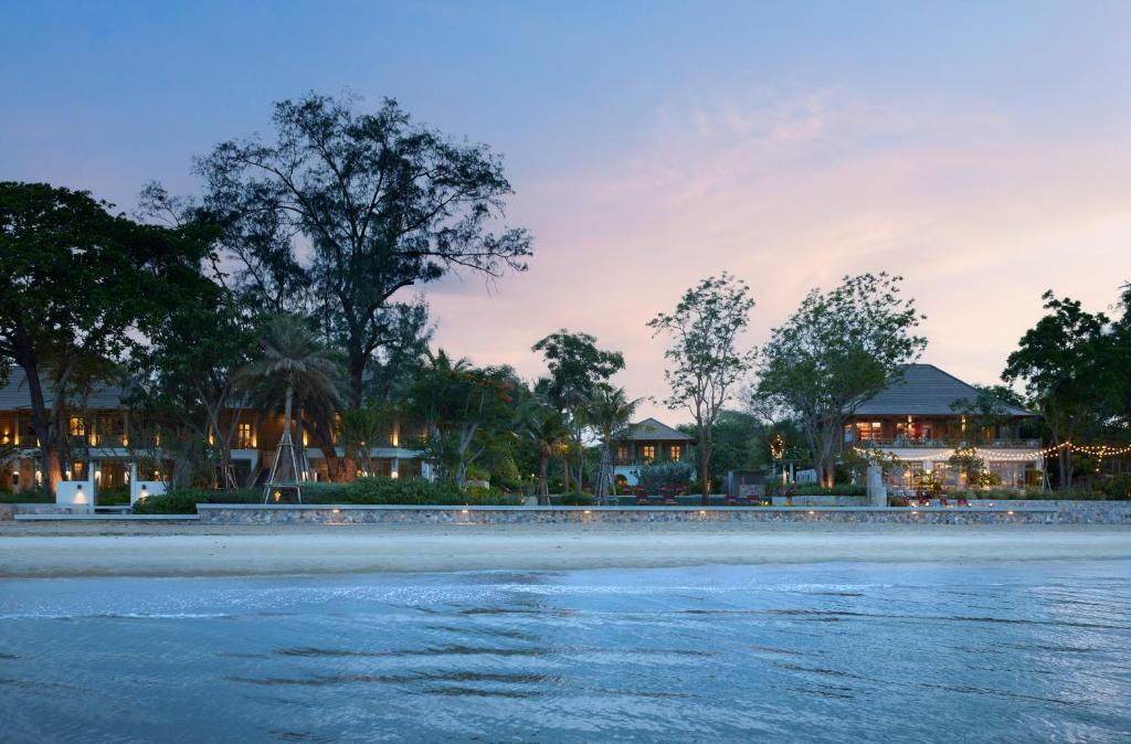 vista su una spiaggia con case sullo sfondo di Charras Bhawan Hotel and Residences a Hua Hin