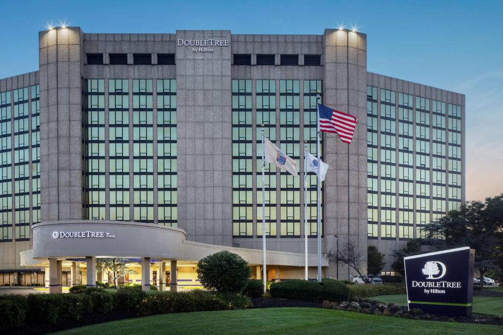 een gebouw met twee vlaggen ervoor bij DoubleTree by Hilton Cherry Hill Philadelphia in Cherry Hill