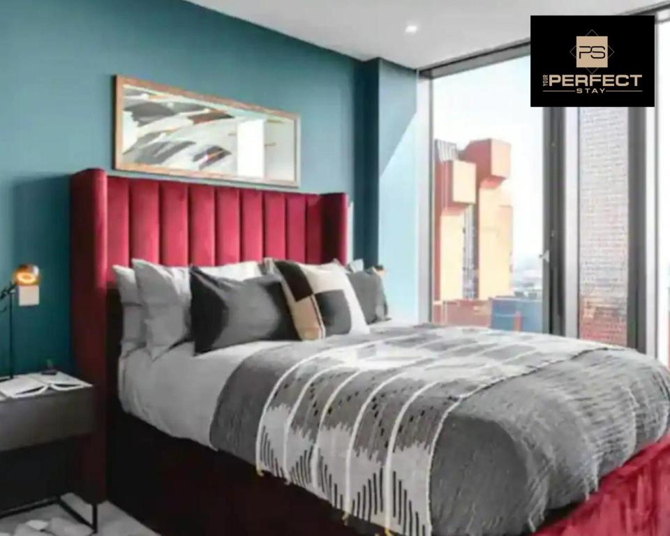 Mercian Luxury Aparthotel - Birmingham City Centre - Your Perfect Stay - 24 Hour Gym Rooftop Terrace Cinema Room في برمنغهام: غرفة نوم بسرير كبير مع اللوح الأمامي الأحمر