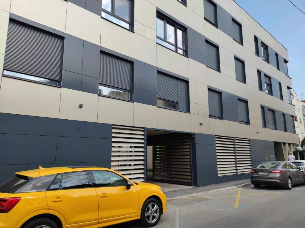 a yellow car parked in front of a building at Apartman Waldy in Osijek