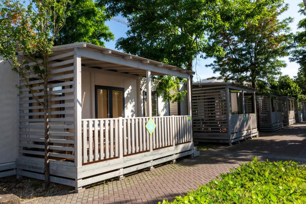 una cabina in legno con una recinzione bianca e alberi di hu Roma Camping In Town a Roma