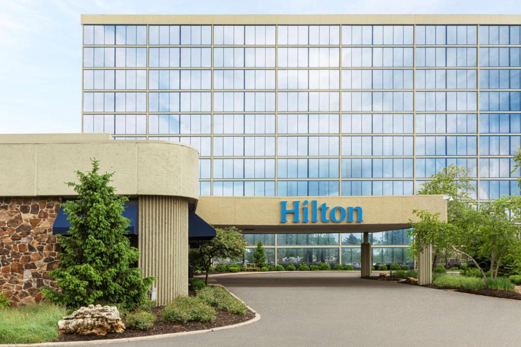 Hilton Kansas City Airport في كانساس سيتي: مبنى امامه لوحة هيلتون