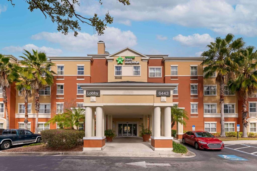 duży budynek pomarańczowy z palmami przed nim w obiekcie Extended Stay America Suites - Orlando - Convention Center - 6443 Westwood w Orlando